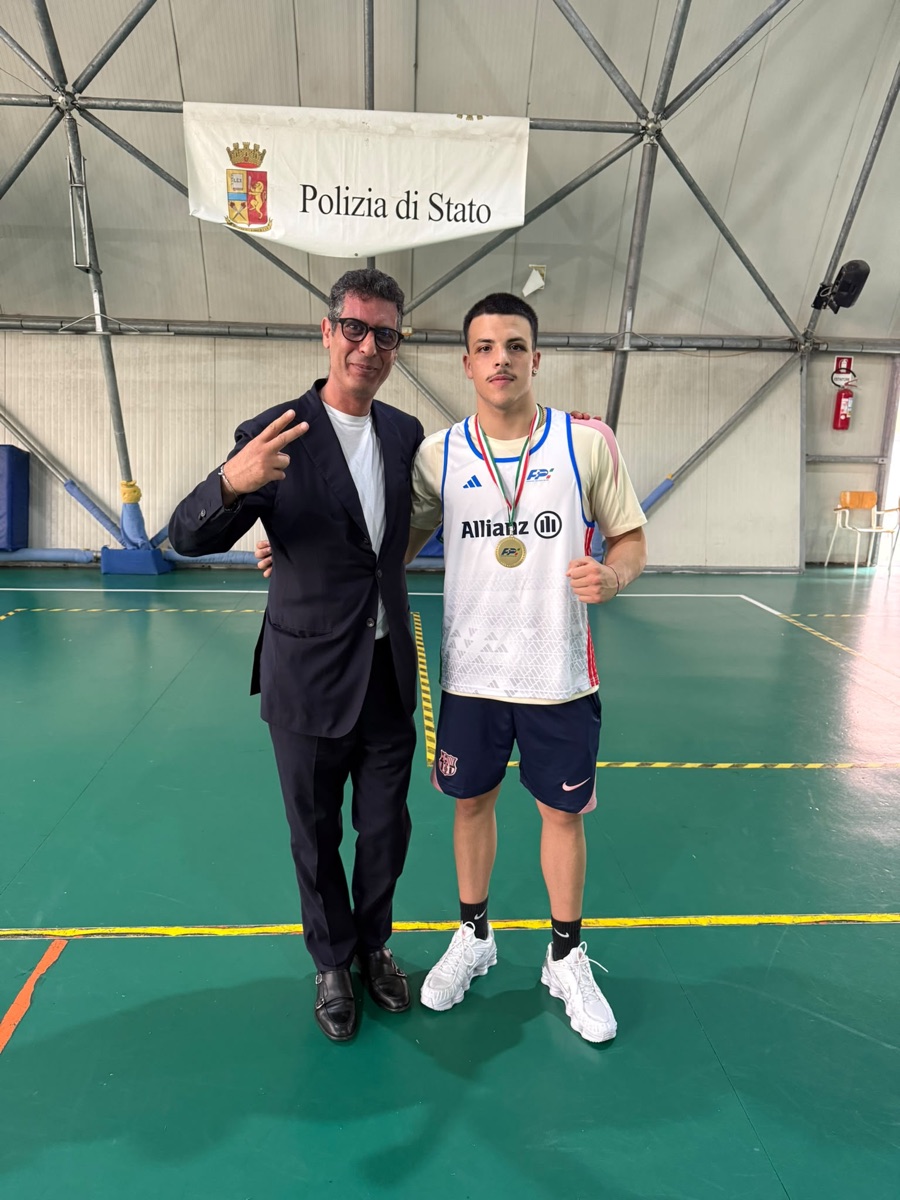 Gianluca Cricrì accanto a un giovane atleta premiato con una medaglia